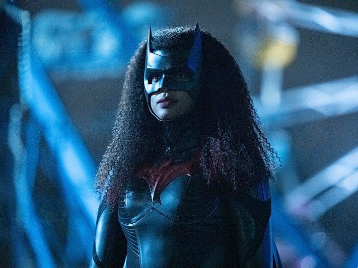 javicia leslie as batwoman in the cw series, wearing a bat mask with her dark, curly hair worn down