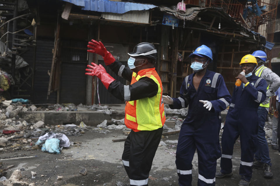 Olufemi Oke- Osanyintolu, director general of Lagos State Emergency Management Agency, left, directs a crane operator at the site of a fire in Balogun Market in downtown Lagos, Nigeria, Nov. 6, 2019. (Photo: Sunday Alamba/AP)