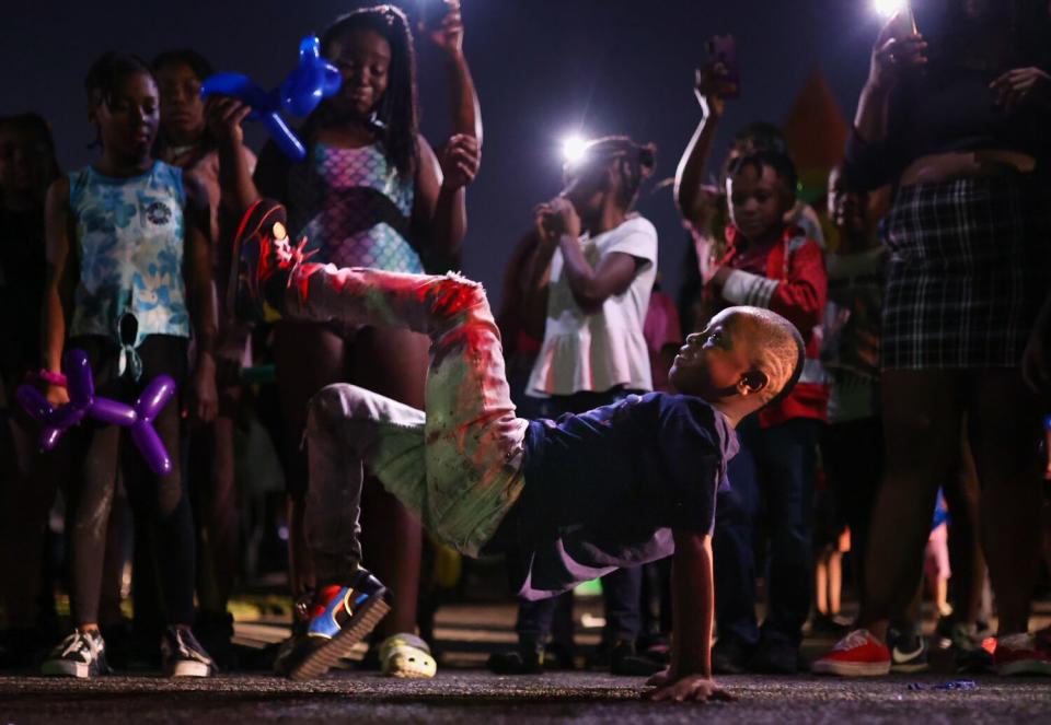 A child dances in a ring of peers.