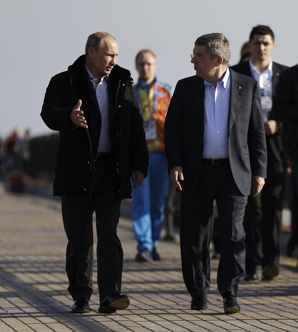 Russian President Vladimir Putin, left, and International Olympic Committee President Thomas Bach walk along the promenade on the Black Sea near the Olympic Park at the 2014 Winter Olympics, Saturday, Feb. 15, 2014, in Sochi, Russia. (AP Photo/David Goldman)