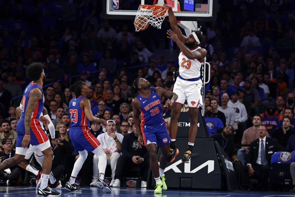 New York Knicks center Mitchell Robinson (23) dunks over Detroit Pistons center Isaiah Stewart (28) during the first half of an NBA basketball game Friday, Oct. 21, 2022, in New York. (AP Photo/Adam Hunger)