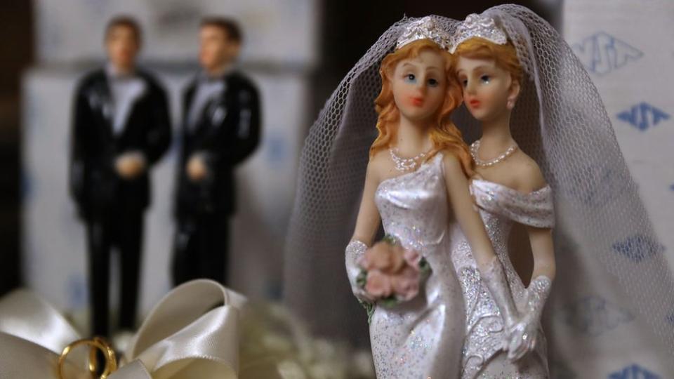 Figuritas de torta de boda: dos mujeres y dos hombres al fondo