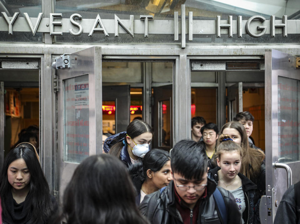 Students at Stuyvesant High School leave after classes end for the week, Friday, March 13, 2020, in New York. As concerns continue to grow around the spread of Covid-19, the city's Mayor Bill de Blasio has been reluctant to close the school system because of the consequences for students and families. (AP Photo/Bebeto Matthews)