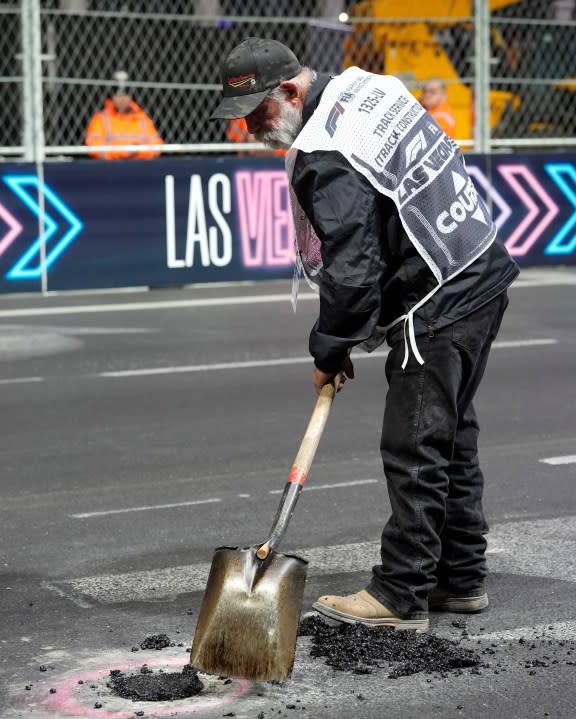 A worker fills in a hole before the start of the second practice session for the Formula One Las Vegas Grand Prix auto race, Friday, Nov. 17, 2023, in Las Vegas. (AP Photo/Nick Didlick)