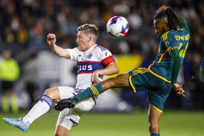 Vancouver Whitecaps midfielder Ryan Gauld, left, and LA Galaxy forward Raheem Edwards vie for the ball during the second half of an MLS soccer match in Carson, Calif., Saturday, March 18, 2023. (AP Photo/Ringo H.W. Chiu)