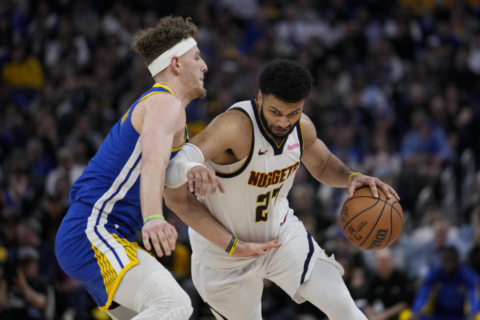 Denver Nuggets guard Jamal Murray, right, moves the ball while defended by Golden State Warriors guard Brandin Podziemski during the first half of an NBA basketball game Sunday, Feb. 25, 2024, in San Francisco. (AP Photo/Godofredo A. Vásquez)