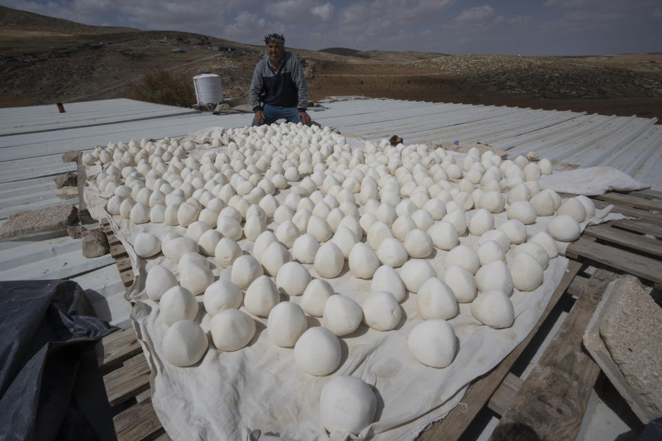 Palestinian Issa Abu Eram displays his local production of Jameed, a dried yogurt and a traditional Bedouin ingredient at the roof of his house, in the West Bank Beduin community of Jinba, Masafer Yatta, Friday, May 6, 2022. Israel's Supreme Court has upheld a long-standing expulsion order against eight Palestinian hamlets in the occupied West Bank, potentially leaving at least 1,000 people homeless. (AP Photo/Nasser Nasser)