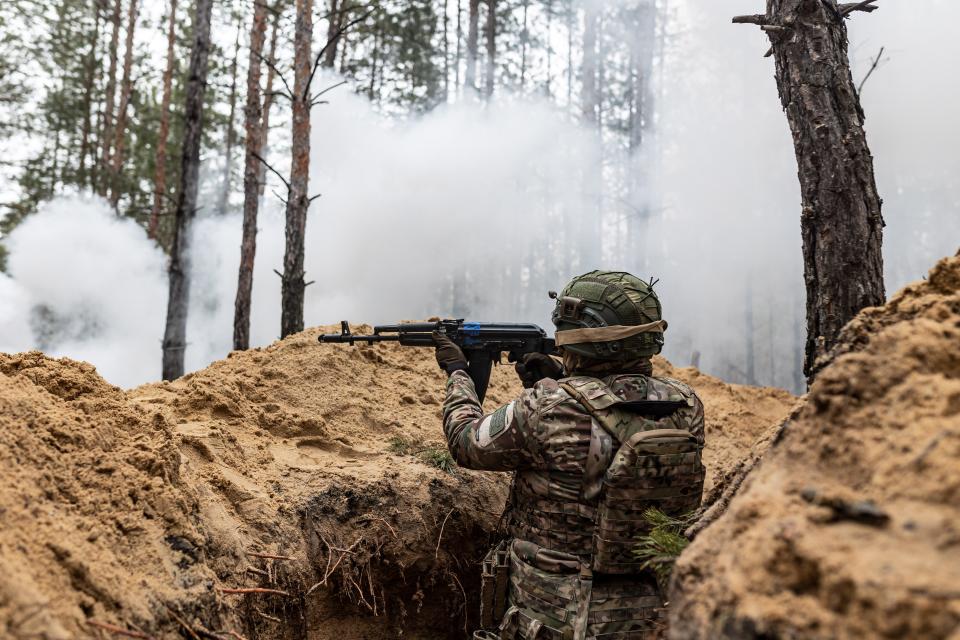 A Ukrainian soldier from the Khartia Brigade fires an AK-47 pellet gun from a trench during a training exercise during the Russo-Ukrainian War in Donetsk Oblast, Ukraine, Feb. 7, 2024.