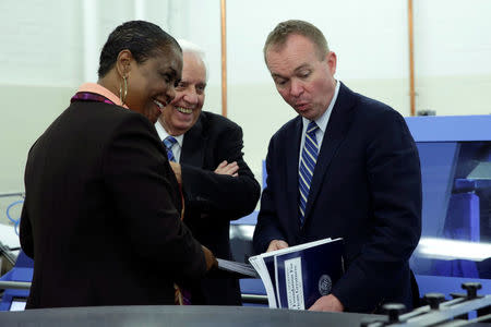 Office of Management and Budget (OMB) Director Mick Mulvaney (R) reacts next to Government Publishing Office Director Davita Vance-Cooks (L) as they inspect the FY2018 budget production run in Washington, U.S., May 19, 2017. REUTERS/Yuri Gripas