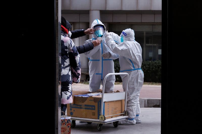 Pandemic prevention workers in protective suits get ready to enter an apartment building that went into lockdown as coronavirus disease (COVID-19) outbreaks continue in Beijing