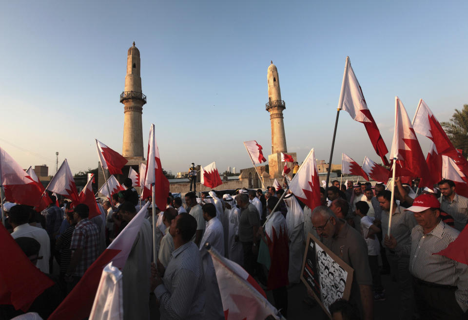 File - In this Friday, Nov. 22, 2013 file photo, Bahraini anti-government protesters wave national flags during a march in Manama, Bahrain. A decade ago, against all odds, a popular uprising convulsed the monarchy of Bahrain as a wave of revolutionary protests swept across the Middle East. But after a brutal crackdown and years of escalating repression, activists say the small kingdom is less free now than even before the Arab Spring, as authorities crush hopes for political reform. (AP Photo/Hasan Jamali, File)