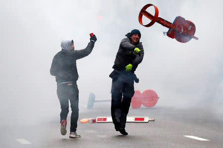 Far-right supporter throws a traffic sign during a protest against Marrakesh Migration Pact in Brussels, Belgium December 16, 2018. REUTERS/Francois Lenoir