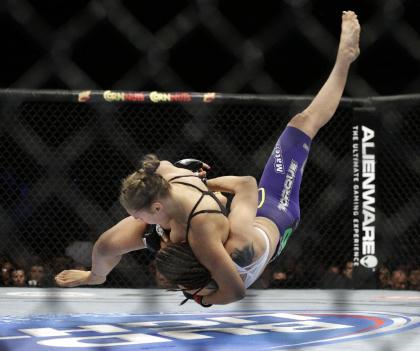 Ronda Rousey takes down Alexis Davis during their women's bantamweight title fight. (AP)