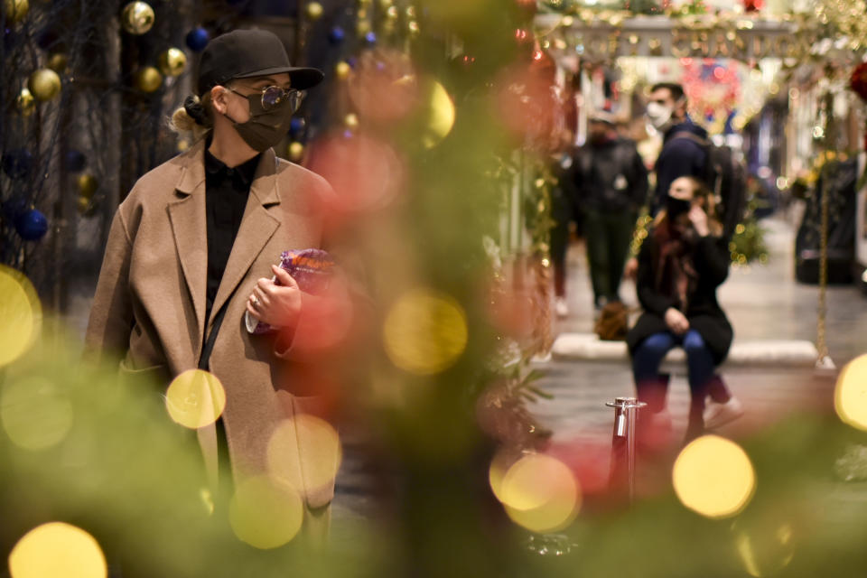 Shoppers wear a face masks at the Burlington Arcade in London, Tuesday, Dec. 22, 2020. Britain's government has imposed new restrictions across many regions, in an effort to restrict the spread of the new mutant coronavirus variant during Christmas festivities. (AP Photo/Alberto Pezzali)