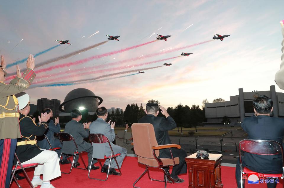 North Korea's leader Kim Jong Un watches planes during a flypast at the Defense Development Exhibition, in Pyongyang, North Korea