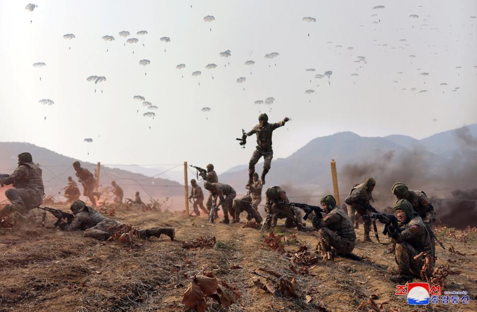 A North Korean soldier is seen leaping in the air beside other personnel during military training.