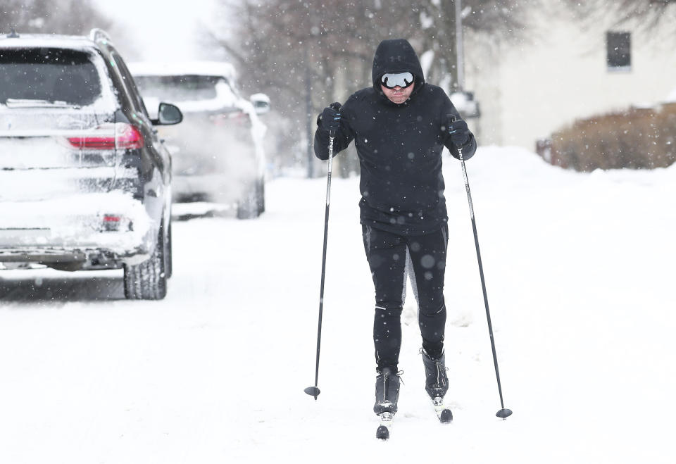 Mike Draves skis down a snowy road in Buffalo, N.Y., on Monday, Dec. 26, 2022. Clean up is currently under way after a blizzard hit four Western New York counties. (Joseph Cooke/The Buffalo News via AP)