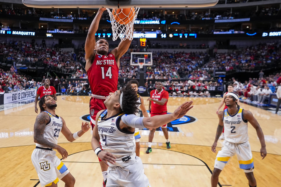 North Carolina State's Casey Morsell (14) scores a gasket in front of Marquette's David Joplin (23), Stevie Mitchell (4) and Chase Ross (2) during the first half of a Sweet 16 college basketball game in the NCAA Tournament in Dallas, Friday, March 29, 2024. (AP Photo/Julio Cortez)