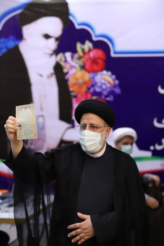 Ebrahim Raisi, Chief Justice of Iran, shows his identification document as he registers as a candidate for the presidential election at the Interior Ministry, in Tehran