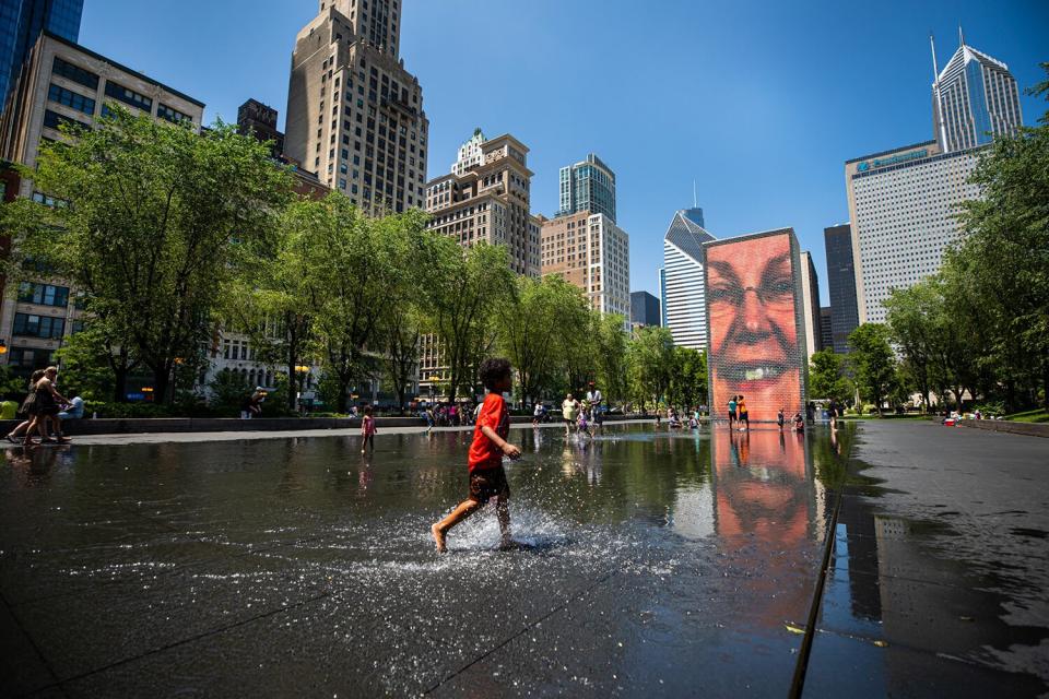 A boy plays with water at Crown Fountain in downtown Chicago, the United States, on June 14, 2022. The Chicago metropolitan area is bracing for a heat wave, as the U.S. National Weather Service issued a heat advisory for the area on Monday.
