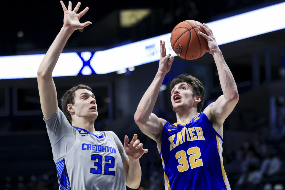 Creighton center Ryan Kalkbrenner, left, defends as Xavier forward Zach Freemantle drives to the basket in the first half of an NCAA college basketball game, Saturday, Feb. 27, 2021, in Cincinnati. (AP Photo/Aaron Doster)