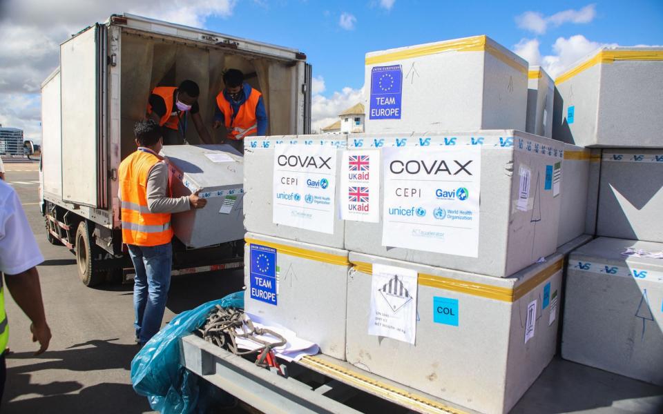 Workers load boxes of Oxford/AstraZeneca Covid-19 vaccines, part of the the Covax programme, in Antananarivo, Madagascar earlier this month - MAMYRAEL/AFP