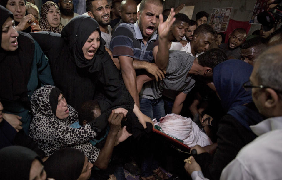 Palestinian relatives of 23 year-old Hamas fighter, Ahmad Morjan, mourn at the family home during his funeral, in the Jabaliya refugee camp, Northern Gaza Strip, Tuesday, Aug. 7, 2018. The Israeli military said it targeted a Hamas military post in northern Gaza after militants opened fire, and Hamas said two of its fighters were killed. (AP Photo/Khalil Hamra)