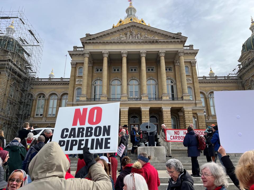 An Iowan holds up a sign at a rally at the Iowa Capitol on Feb. 21, 2023 in opposition to the use of eminent domain by carbon capture pipelines in Iowa.