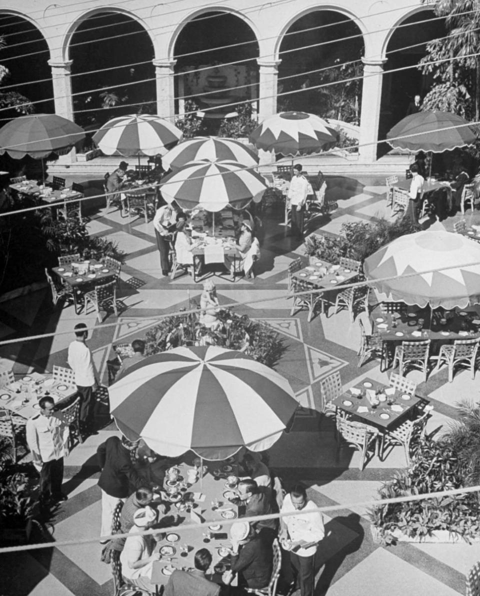 Guests enjoying al fresco lunch on the garden patio, 1940 - Credit: Life Picture Collection/Getty