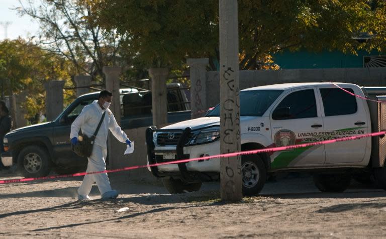 A forensic specialist outside a house in which eight members of a family were killed by gunmen in Ciudad Juarez, Mexico, on November 17, 2013