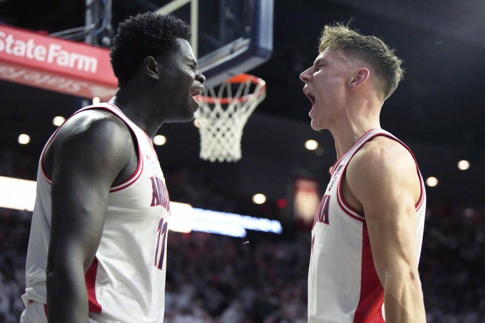 Arizona center Oumar Ballo (11) and guard Pelle Larsson celebrate during the second half of an NCAA college basketball game against UCLA, Saturday, Jan. 21, 2023, in Tucson, Ariz. Arizona won 58-52. (AP Photo/Rick Scuteri)