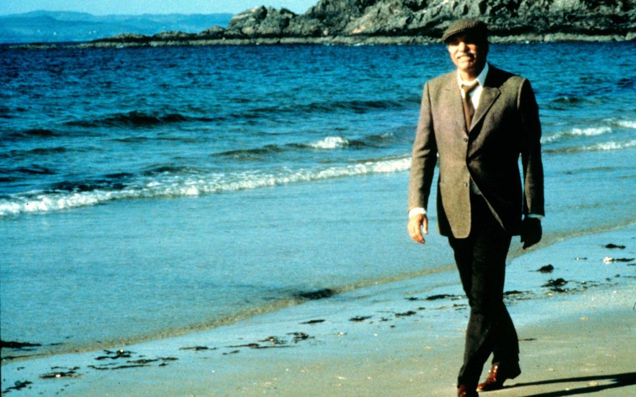 Burt Lancaster as Felix Happer walking along the fictional Ferness beach in Local Hero - Moviestore Collection Ltd / Alamy Stock Photo