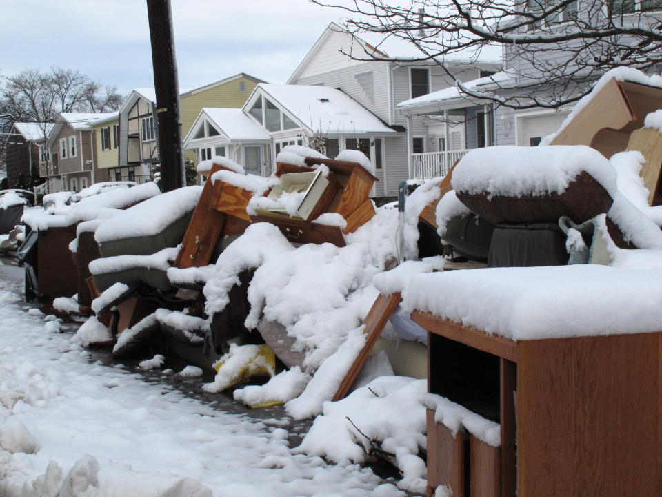 Four inches of snow covers piles of debris from Superstorm Sandy in Point Pleasant Beach, N.J. on Thursday Nov. 8, 2012, a day after a nor'easter hit the storm-weary state. Emergency dunes seemed to have held during the recent storm, and flooding that had been feared did not materialize. (AP Photo/Wayne Parry)