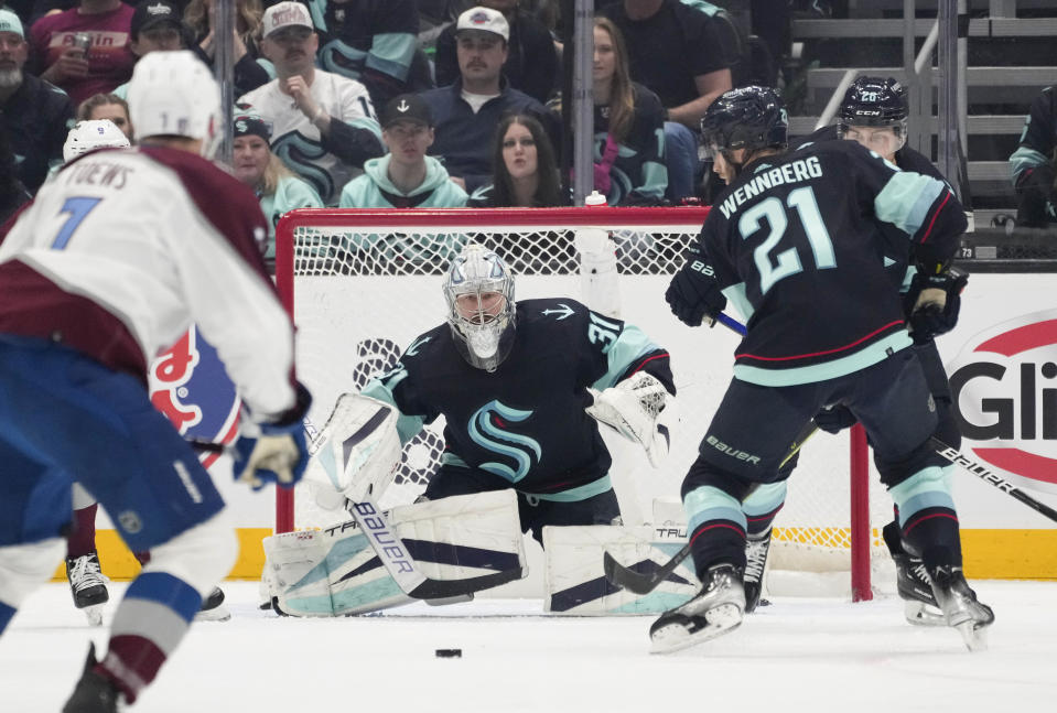 Seattle Kraken goaltender Philipp Grubauer (31) watches the puck, which is between Colorado Avalanche defenseman Devon Toews (7) and Kraken center Alex Wennberg (21) during the first period of Game 6 of an NHL hockey Stanley Cup first-round playoff series Friday, April 28, 2023, in Seattle. (AP Photo/Lindsey Wasson)