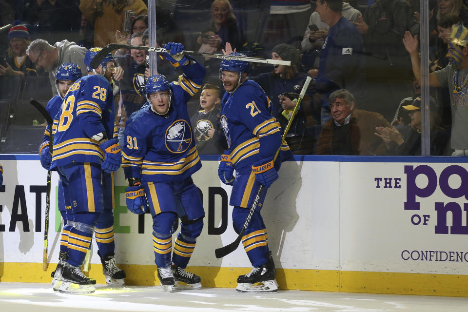 Buffalo Sabres center Drake Caggiula (91) celebrates with center Zemgus Girgensons (28), and right wing Kyle Okposo (21) after scoring a goal during the second period of an NHL hockey game against the Tampa Bay Lightning, Monday, Oct. 25, 2021, in Buffalo, N.Y. (AP Photo/Joshua Bessex)