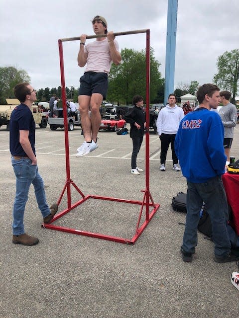 BNL junior Joseph Brazzell takes the pull-up challenge at the US Marine Corps recruiting table Wednesday at the NLCC car show.