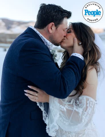 <p>markandjenna.pic-time.com</p> Ian Flanigan and Kelsey kiss on their wedding day