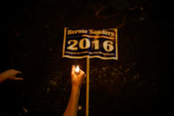 <p>A sign which reads, “Bernie Sanders, 2016” lies next to a protester holding a candle during a vigil on the perimeters of the 2016 Democratic National Convention in Philadelphia, Pennsylvania, July 26, 2016. (Photo: Adrees Latif/Reuters)</p>