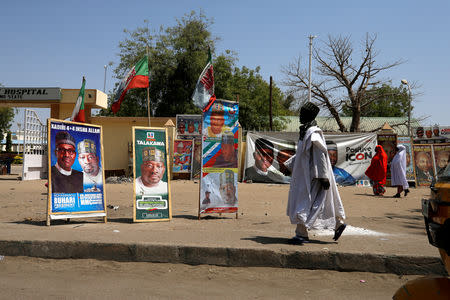 A man walks past campaign posters after Nigeria's presidential election was postponed in Maiduguri, Nigeria February 17, 2019. REUTERS/Afolabi Sotunde