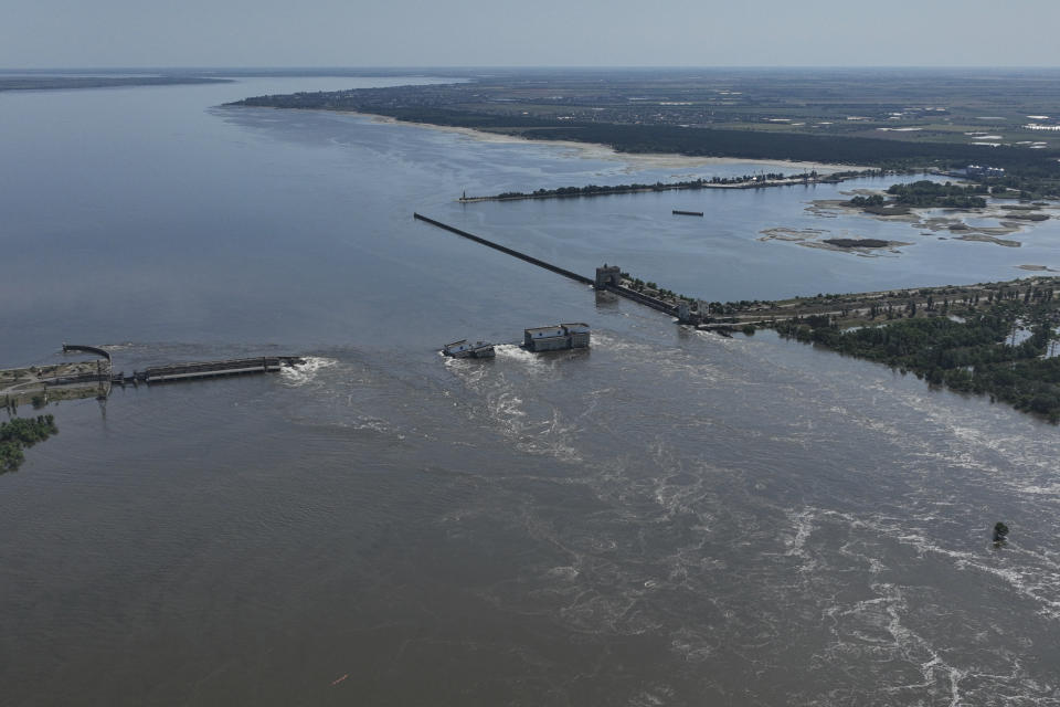 Un torrente de agua fluye por encima de la derrumbada represa de Kajovka, en Nova Kajovka, en territorio ucraniano ocupado por Rusia, el 7 de junio de 2023. (AP Foto)