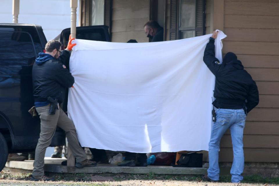 Investigators block the public's view as bodies are removed from the scene of a shooting on  Feb. 2 in Muskogee, Okla.