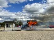 A building constructed using traditional materials and landscaping is engulfed by flames during a burn demonstration at the National Interagency Fire Center in Boise, Idaho, Monday, April 29, 2024. The building on the right was also exposed to flames during the demonstration, but it was built using fire-resistant materials and was mostly protected from damage. (AP Photo/Rebecca Boone)