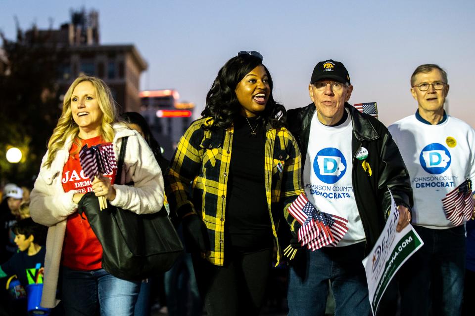 Democratic candidate for governor Deidre DeJear, second from left, walks with supporters during the University of Iowa Homecoming parade, Friday, Oct. 28, 2022, in Iowa City, Iowa.