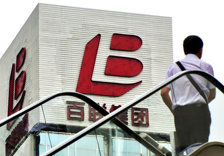 A man walks past a logo of Bailian Group in Shanghai, August 4, 2011. REUTERS/Stringer