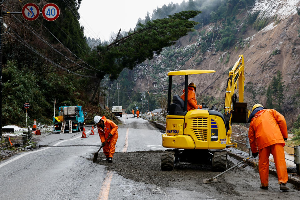 圖為日本石川強震過後，7日工人正在修復受損道路。（路透社）