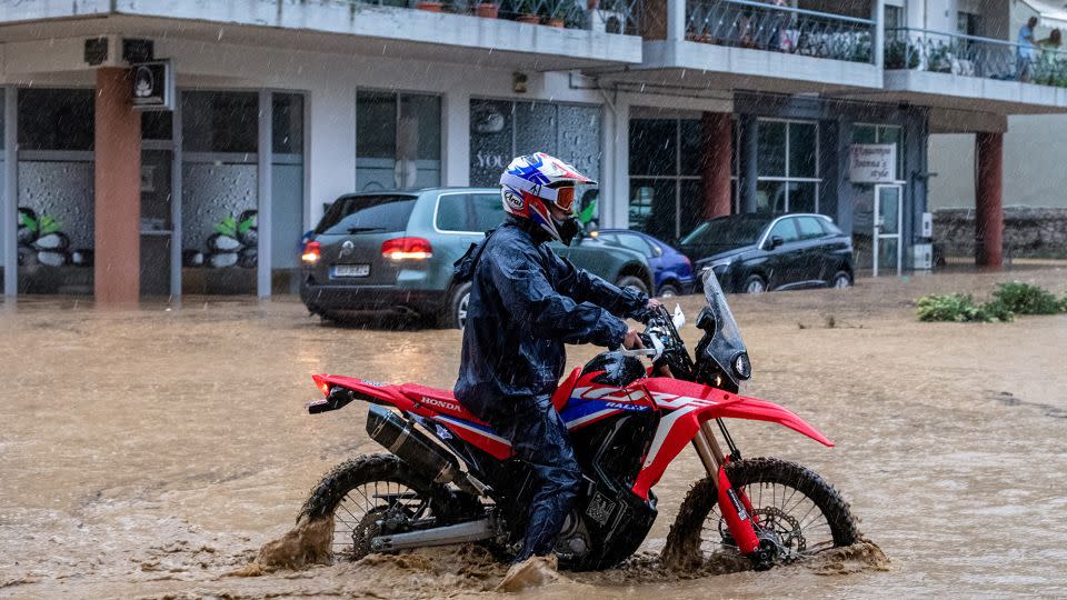 A man drives his bike in rising waters, during a storm in the city of Volos, Greece, September 5, 2023.  - Anastasia Karekla/Eurokinissi/Reuters