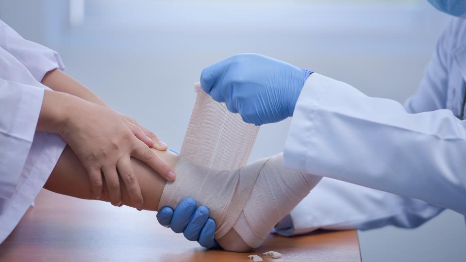 Doctor bandaging a patient's foot