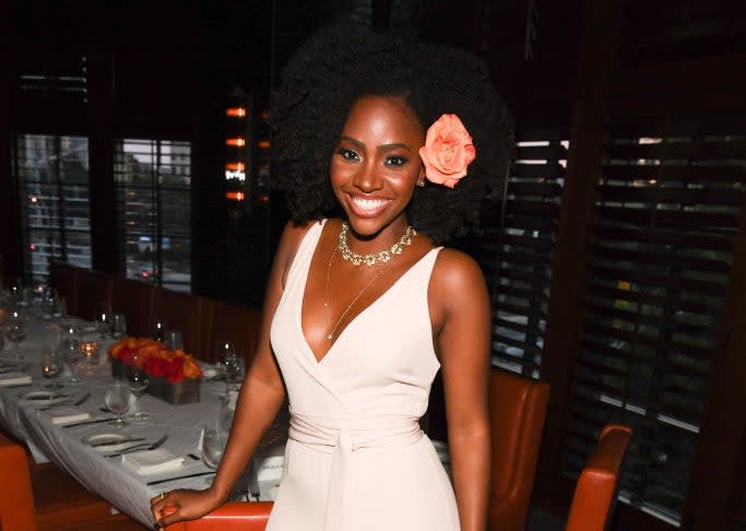 Teyonah smiling in front of a formal table setting