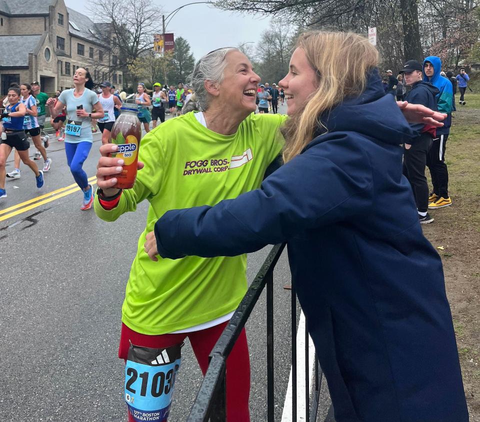 York, Maine's Karen Fogg, left, hugs her daughter, Sydney, a hug near the 22nd-mile marker at Monday's Boston Marathon. Fogg finished her 15th consecutive Boston Marathon in a time of  3 hours, 40 minutes and 23 seconds.