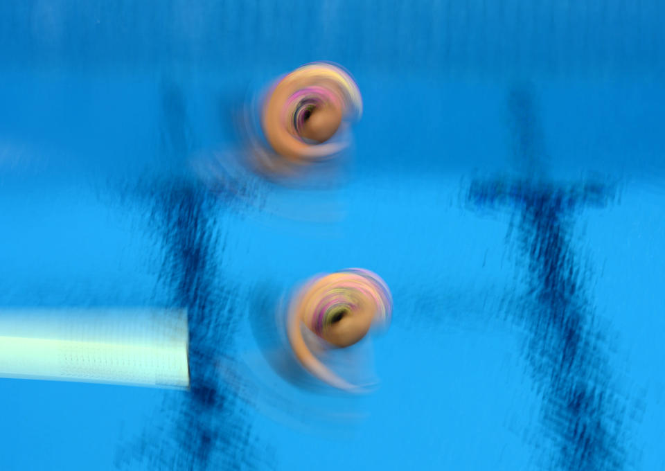 Divers from Malaysia dive in the final of the Womans Synchronised 3m Springboard at the Olympic Games in London, Sunday, July 29, 2012. The pair finished 5th. (AAP Image/Dave Hunt) NO ARCHIVING